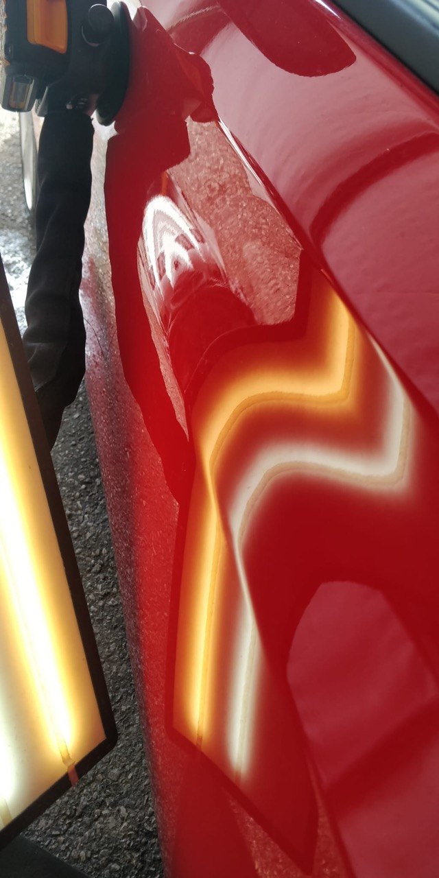 Red car door after paintless dent repair